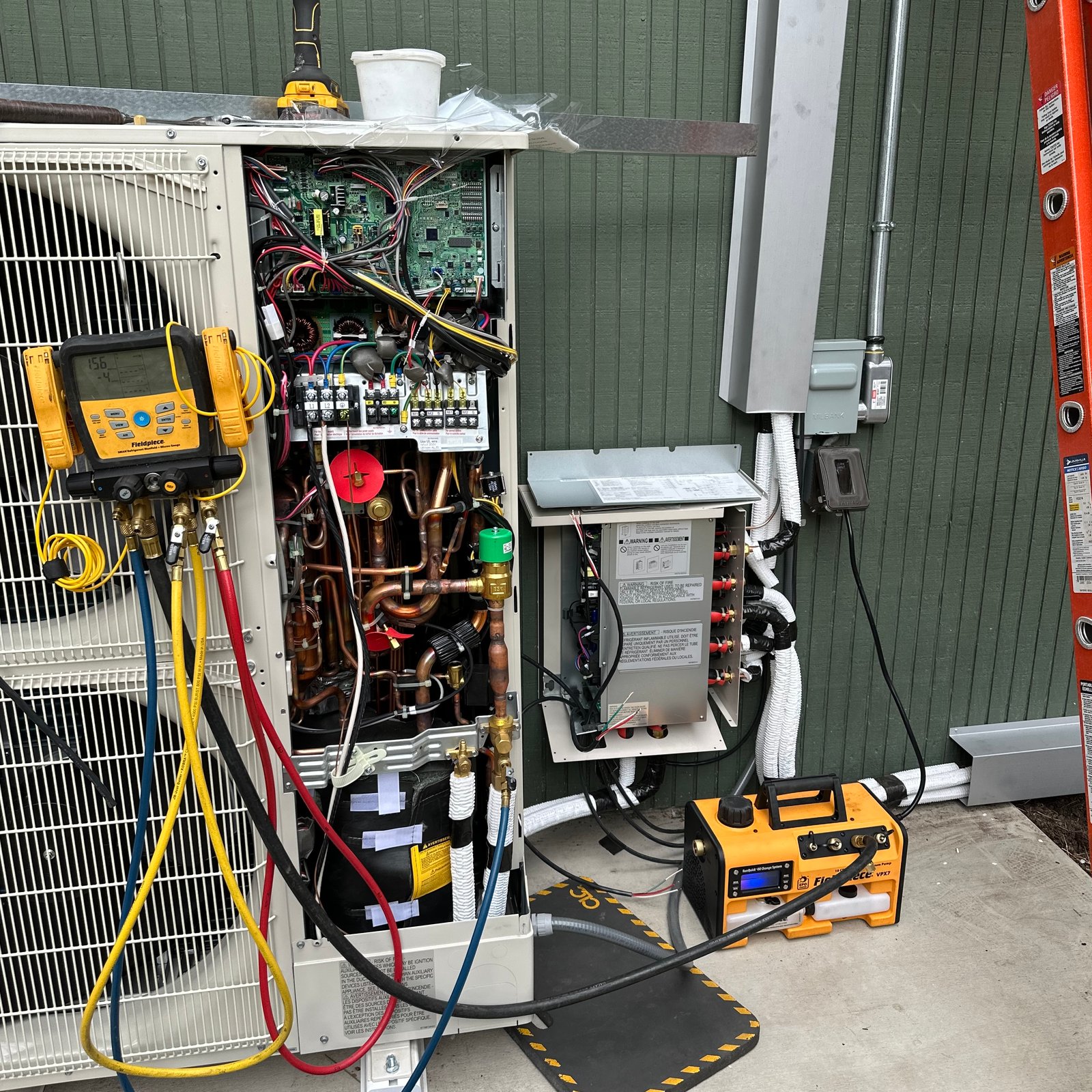 Air Dynamics of Tulsa Owner Stephen performing work on an HVAC unit in Tulsa in front of a home.